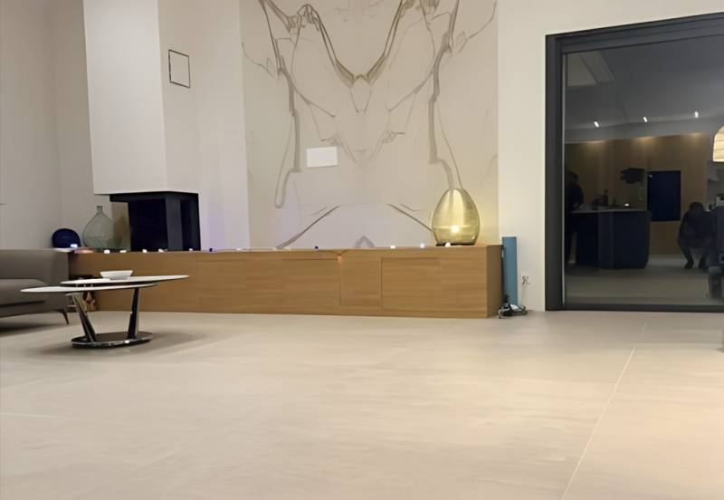 Réalisation en carrelage pour le mur d'un salon pour une villa dans le Gard en grès cérame effet marbre Calacatta Extra au format de 160x320x6 mm